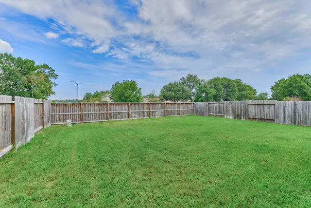 a view of a yard with a wooden fence