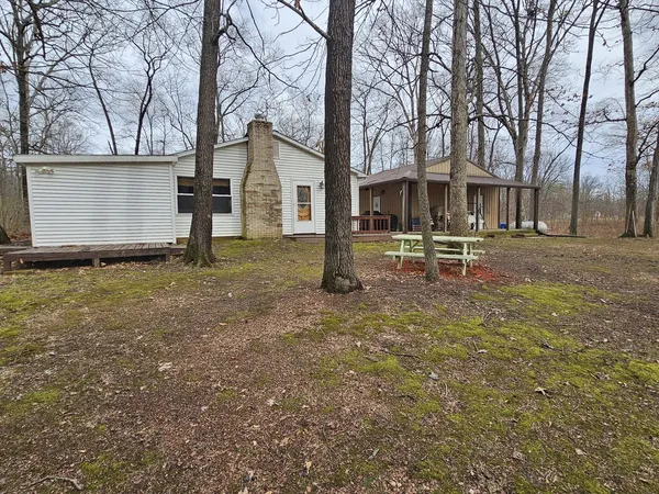 a backyard of a house with table and chairs