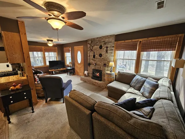 a living room with furniture ceiling fan and a window