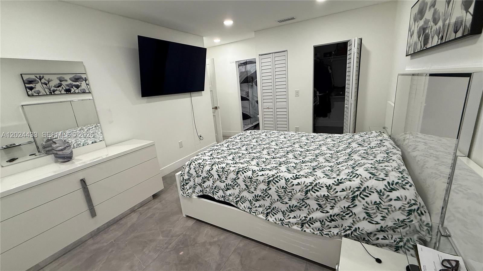 13675 Southwest 62nd Street, Unit 2023 Miami, FL 33183 - Photo 12 of 22 a spacious bedroom with a bed and a flat screen tv