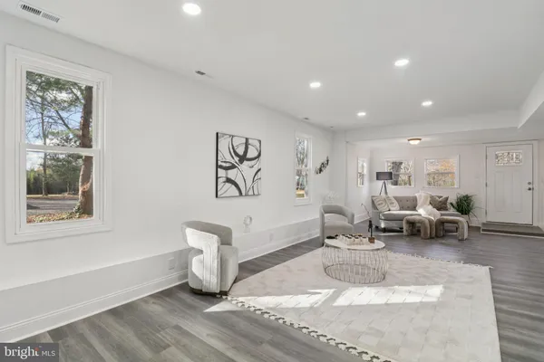 a kitchen with stainless steel appliances granite countertop a stove a refrigerator a sink a dining table and chairs with wooden floor