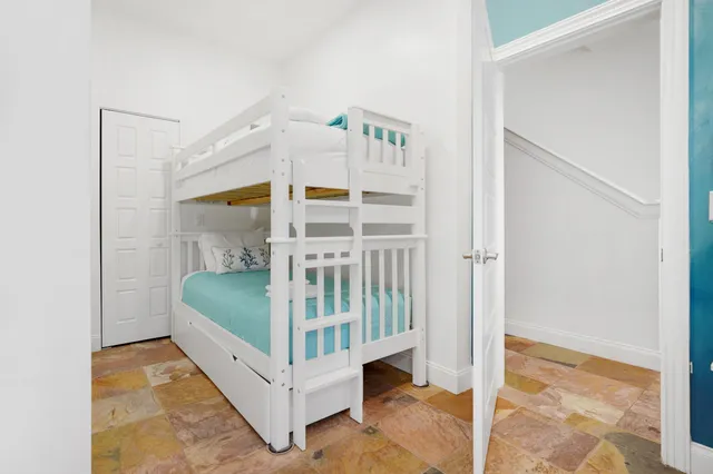 a open kitchen with stainless steel appliances kitchen island granite countertop a stove top oven a sink a dining table and chairs with the wooden floor