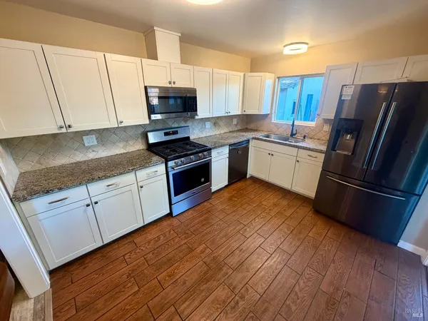 a kitchen with stainless steel appliances granite countertop a refrigerator sink and microwave
