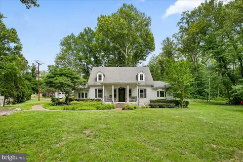 a front view of a house with garden and trees