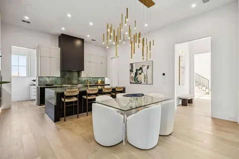 a living room with couches and kitchen view with wooden floor