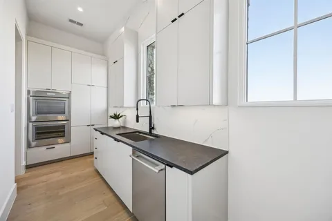 a kitchen with stainless steel appliances granite countertop a sink and a stove