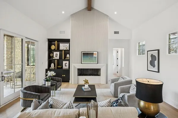 a living room with furniture fireplace and a large window