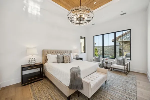 a bedroom with a large bed and a chandelier