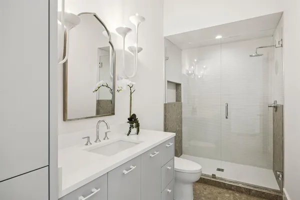 a bathroom with a sink a toilet and shower