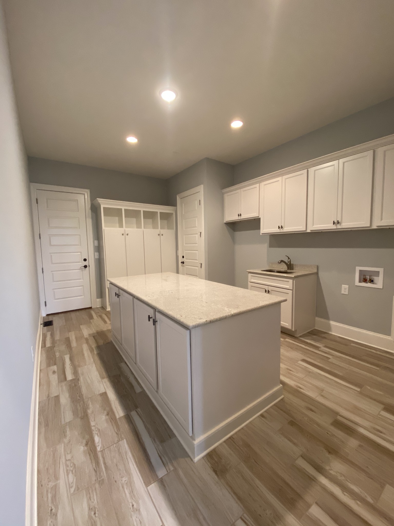 8015 Burning Tree Farms Road Arrington, TN 37014 - Photo 8 of 10 a large white kitchen with wooden floors and white stainless steel appliances