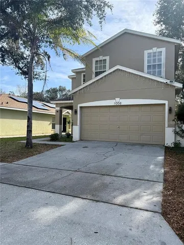 a view of small house with a yard and garage