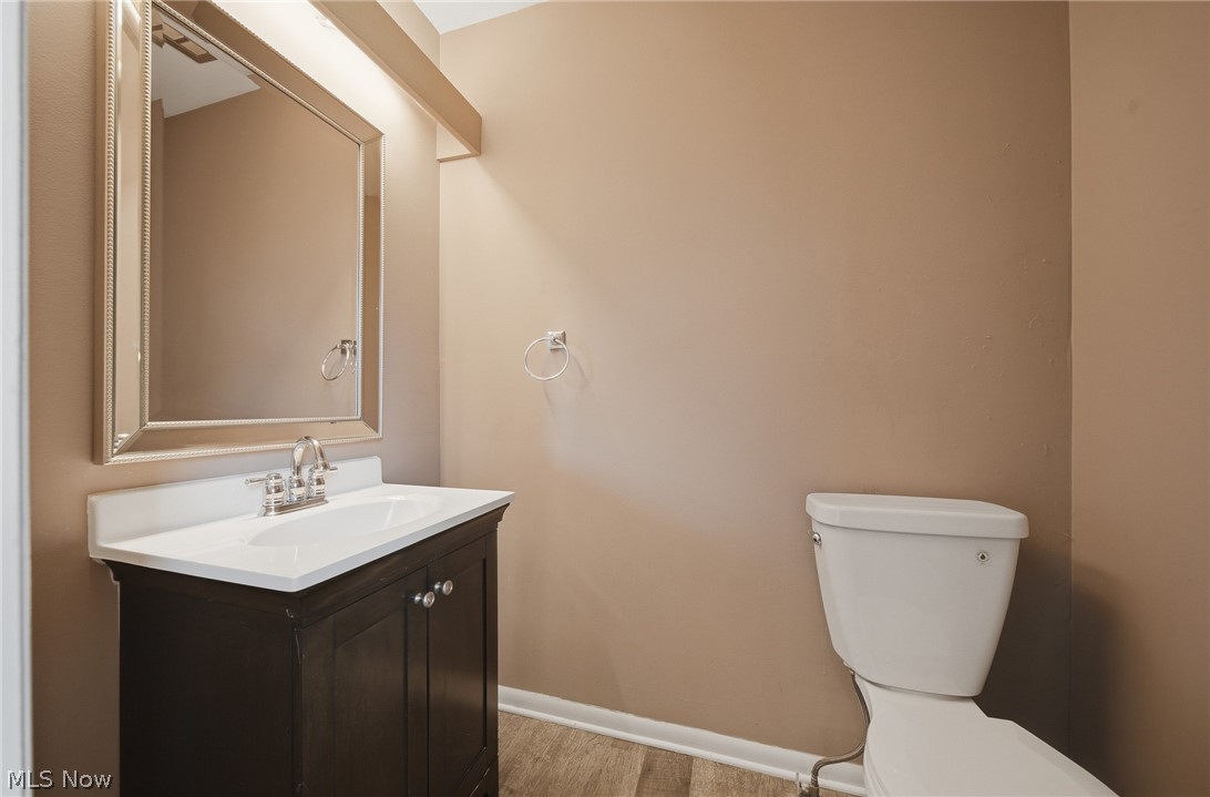 824 South Chillicothe Road, Unit 2 Aurora, OH 44202 - Photo 13 of 42 Bathroom featuring a dark wood-finish vanity with a white countertop and integrated sink, chrome faucet, framed mirror, and wood-finish flooring