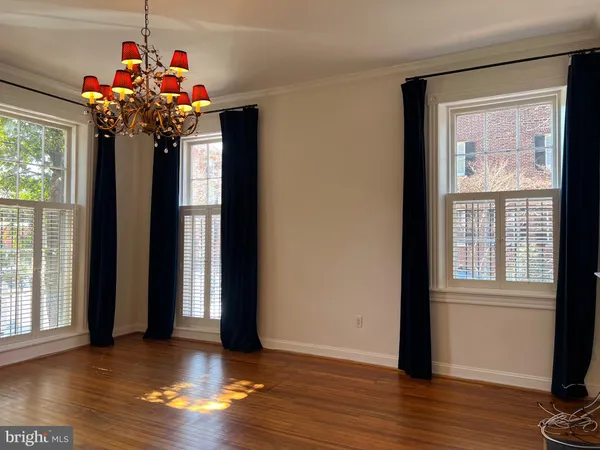 a very nice looking room with wooden floor and windows