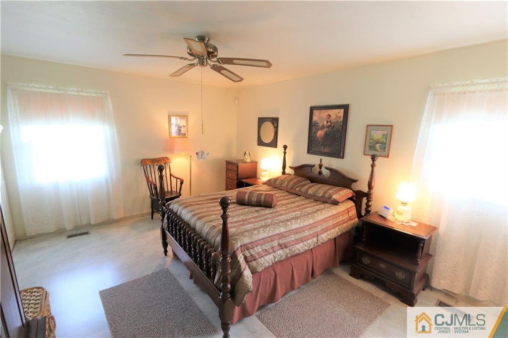 20 Flower Road Somerset, NJ 08873 - Photo 14 of 25 a bedroom with a bed and a chandelier