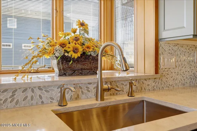 a view of a sink a mirror and next to a window