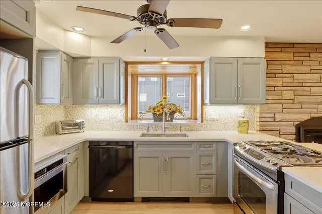 a kitchen with stainless steel appliances a sink stove and cabinets