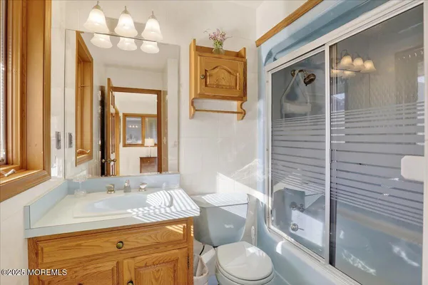 a bathroom with a granite countertop toilet sink and mirror