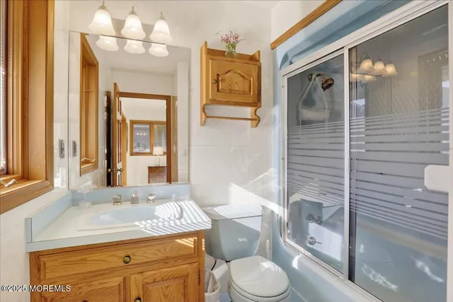 a bathroom with a granite countertop toilet sink and mirror