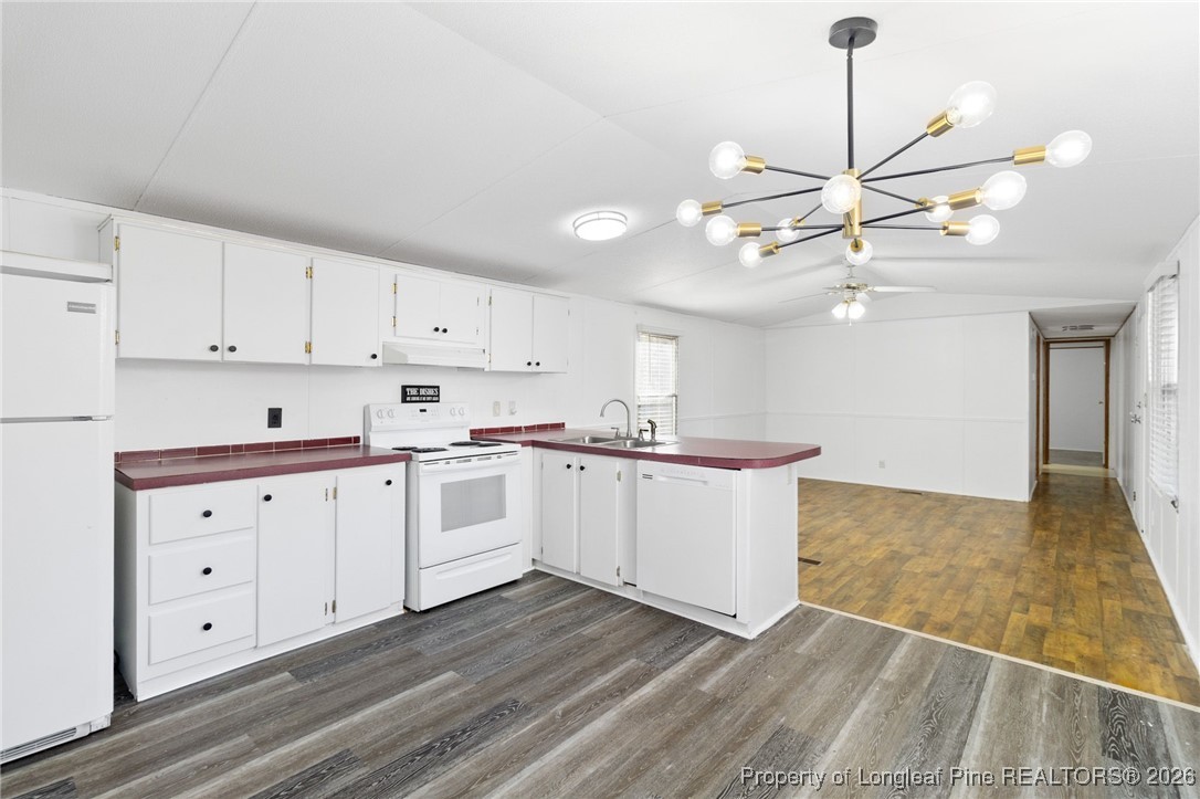 7321 Sheriff Watson Road Sanford, NC 27332 - Photo 8 of 26 a kitchen with granite countertop a stove a sink and white cabinets with wooden floor