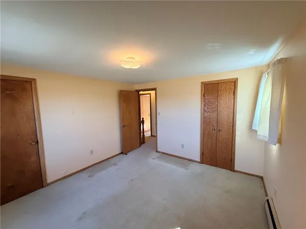 an empty room with closet and wooden door