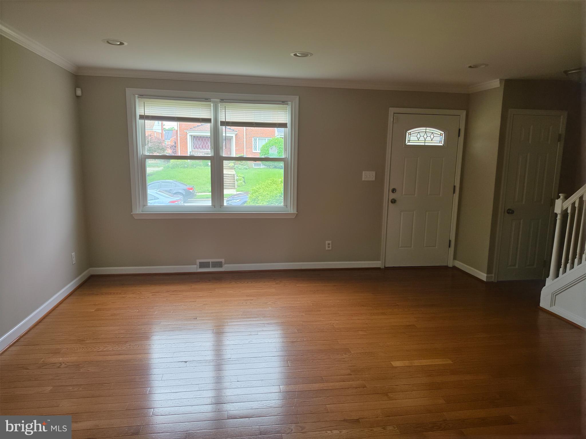 2028 Hillenwood Road Baltimore, MD 21239 - Photo 2 of 18 an empty room with wooden floor and windows