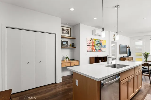 a kitchen that has a lot of cabinets a sink and wooden floor