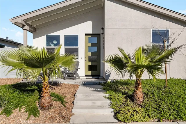 a front view of yellow house with a small yard
