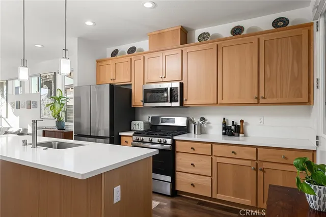 a kitchen with a sink a microwave a refrigerator and cabinets