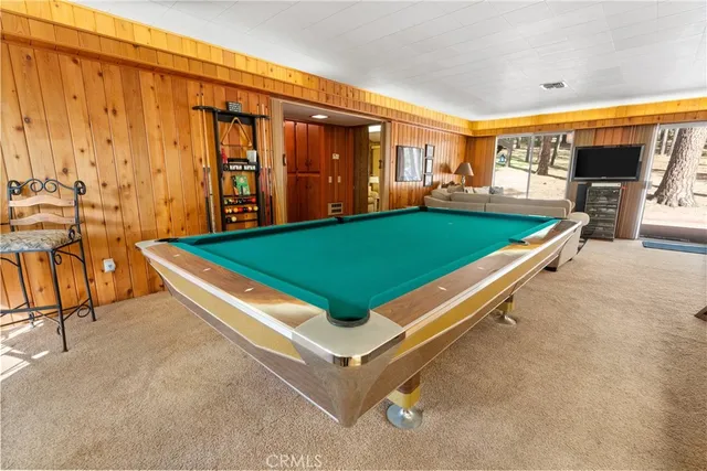 a room with pool table and windows