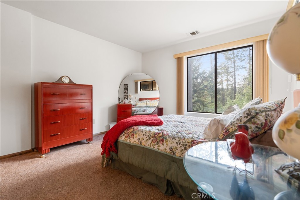 25220 Rim Rock Road Idyllwild, CA 92549 - Photo 32 of 55 a bedroom with a bed and windows