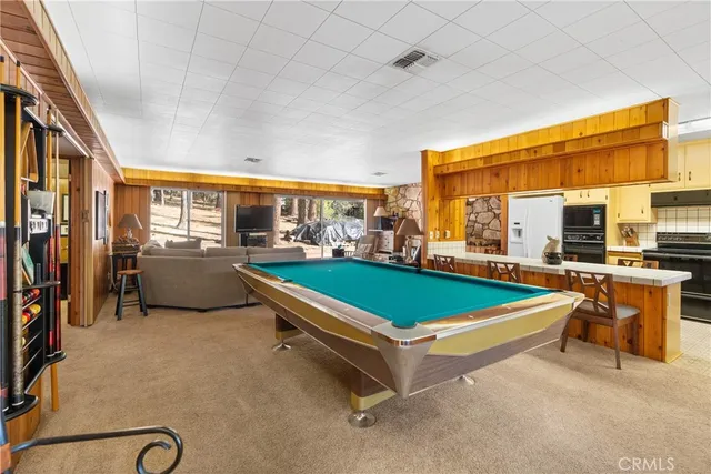 a room with pool table and two windows