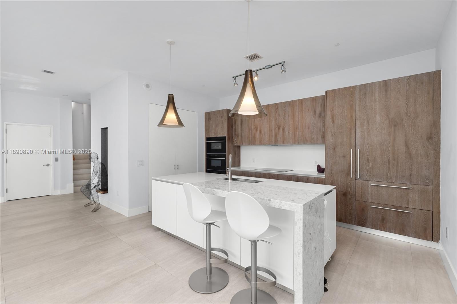650 Northeast 32nd Street, Unit BH7 Miami, FL 33137 - Photo 52 of 53 a view of kitchen island with stainless steel appliances wooden floor dining table and chair