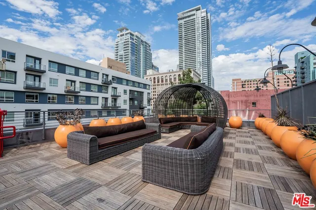 a roof deck with couches and potted plants