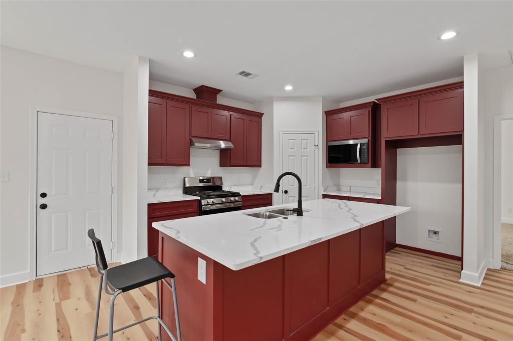 1520 Harris Street Gainesville, TX 76240 - Photo 13 of 24 a kitchen with a sink cabinets and wooden floor