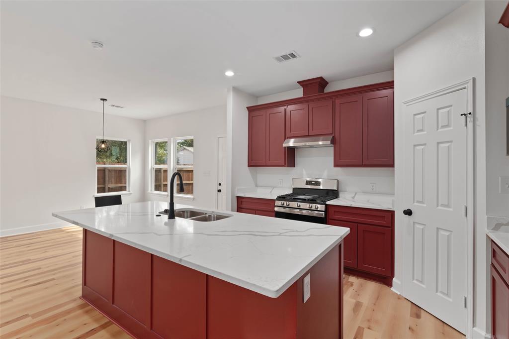 1520 Harris Street Gainesville, TX 76240 - Photo 14 of 24 a kitchen with stainless steel appliances a sink stove and cabinets