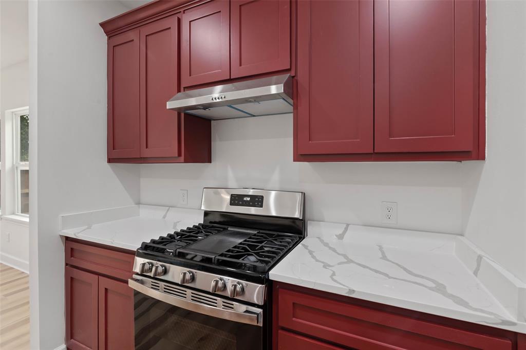 1520 Harris Street Gainesville, TX 76240 - Photo 15 of 24 a kitchen with wooden cabinets and a stove top oven