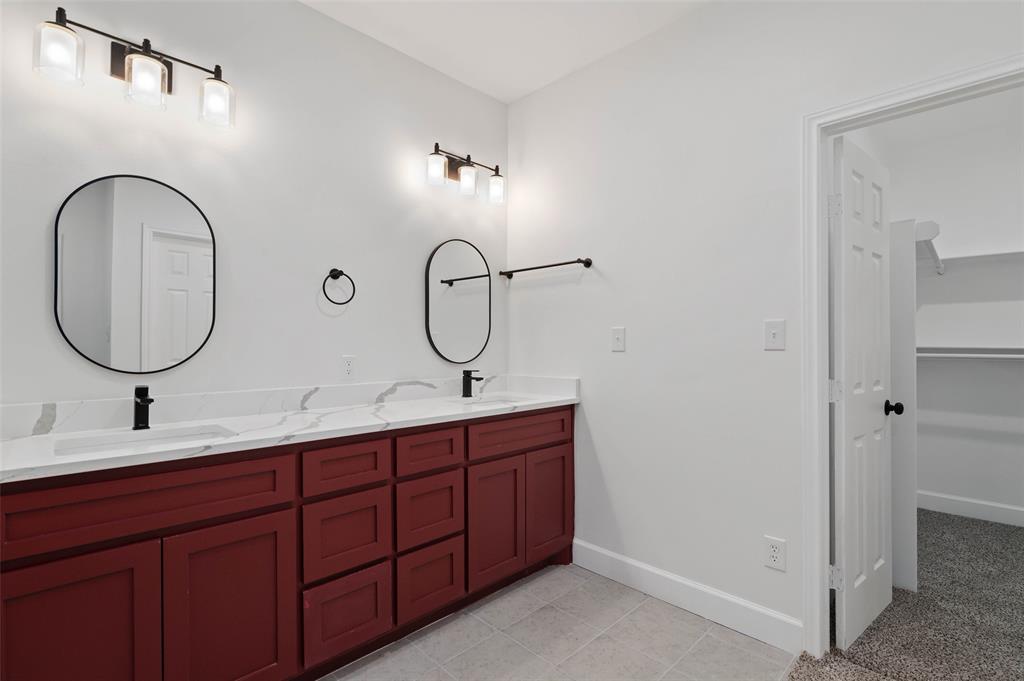 1520 Harris Street Gainesville, TX 76240 - Photo 19 of 24 a bathroom with a double vanity sink and a mirror