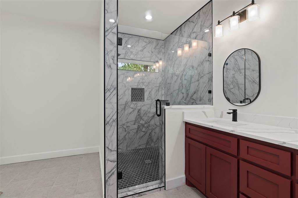 1520 Harris Street Gainesville, TX 76240 - Photo 20 of 24 a bathroom with a sink a mirror and a shower
