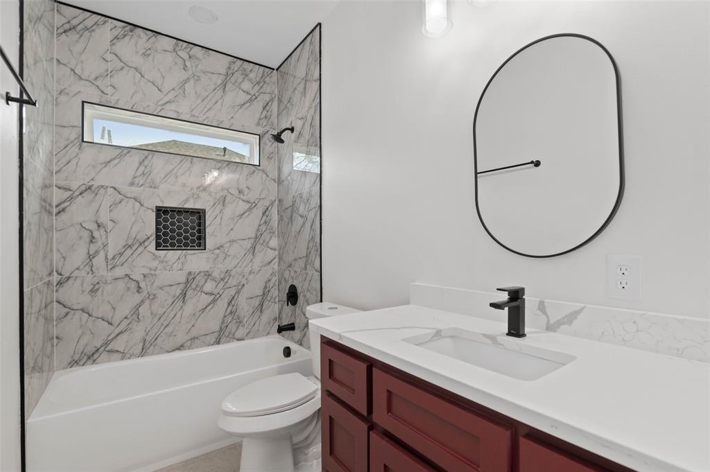 1520 Harris Street Gainesville, TX 76240 - Photo 6 of 24 a bathroom with a sink a toilet and a mirror
