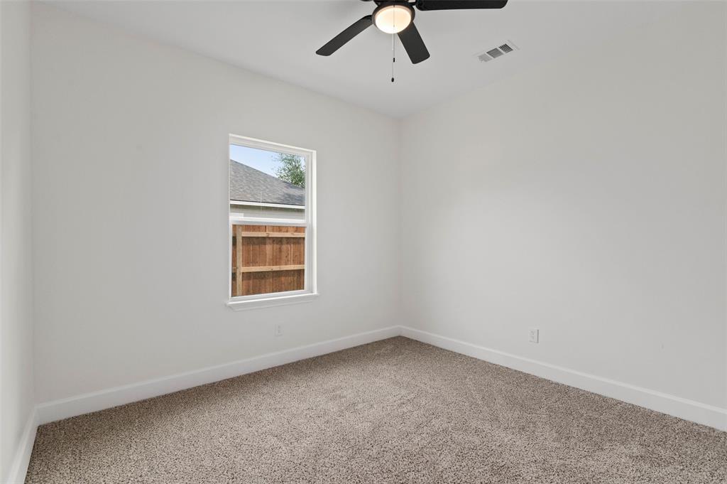 1520 Harris Street Gainesville, TX 76240 - Photo 7 of 24 an empty room with a window and a ceiling fan