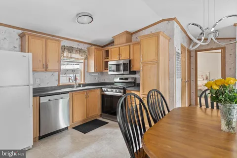 a kitchen with granite countertop a refrigerator stove top oven and sink