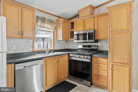 a kitchen with stainless steel appliances granite countertop a stove microwave and refrigerator