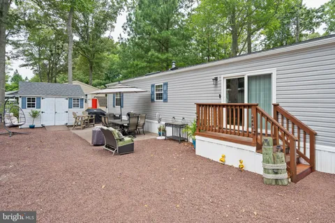 a view of a house with a deck and a yard