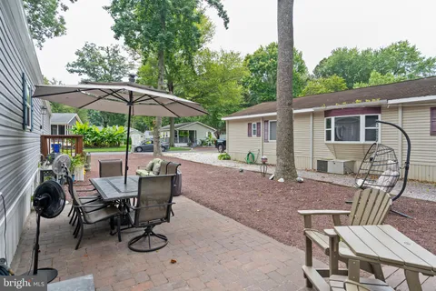 a view of patio with chairs and table under an umbrella