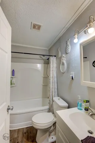 a bathroom with a sink a toilet a mirror and shower