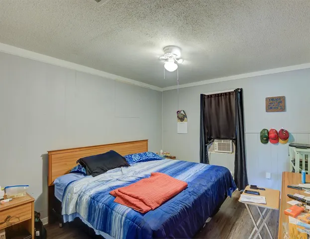 a bedroom with a bed and a refrigerator