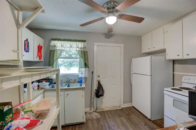 a kitchen with a refrigerator and white cabinets