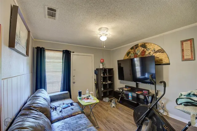 a living room with furniture a flat screen tv and a window
