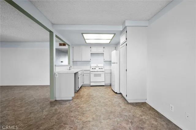 a view of a kitchen with white cabinets