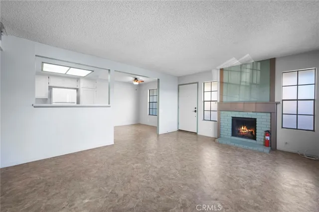 an empty room with windows and fireplace